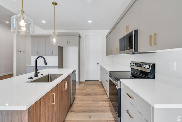 1601 S 3170 E, Spanish Fork, UT 84660 - kitchen featuring appliances with stainless steel finishes, light wood finished floors, light countertops, recessed lighting, and an island with sink