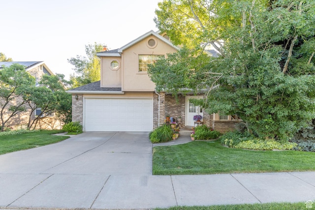 145 Deer Run Ln, Layton, UT 84040 - view of front facade with an attached garage, concrete driveway, a front lawn, stucco siding, and brick siding
