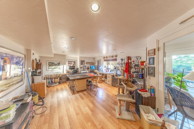 145 Deer Run Ln, Layton, UT 84040 - kitchen with a textured ceiling, a center island, light wood-type flooring, a breakfast bar, and open floor plan