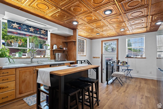 160 S 200 W, Tooele, UT 84074 - kitchen with butcher block countertops, an ornate ceiling, a sink, light wood finished floors, and baseboards