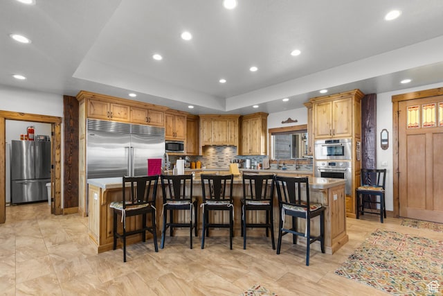 1560 Reserve Dr, Fish Haven, ID 83287 - kitchen featuring built in appliances, a large island, recessed lighting, a tray ceiling, and tasteful backsplash