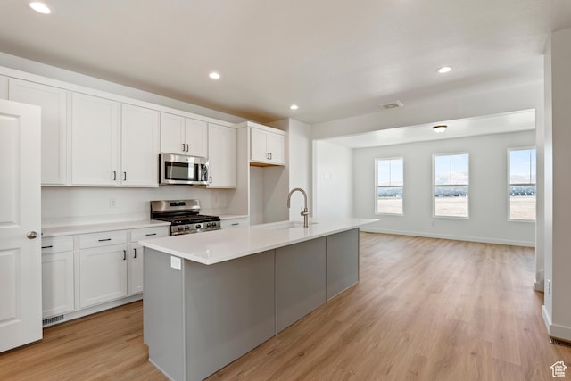 6658 W 11800 S, South Jordan, UT 84009 - kitchen featuring appliances with stainless steel finishes, a sink, light wood-type flooring, light countertops, and white cabinets