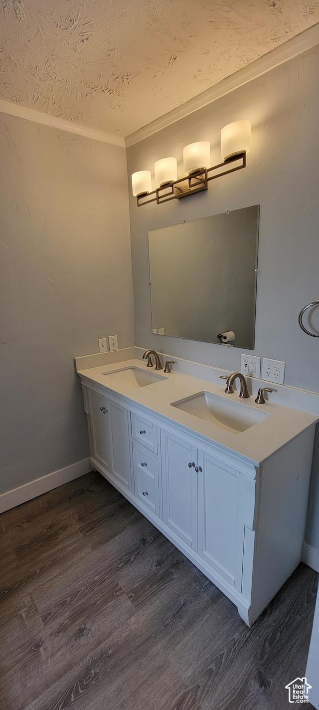325 W Apple St, Grantsville, UT 84029 - bathroom with wood finished floors, double vanity, baseboards, and a textured ceiling
