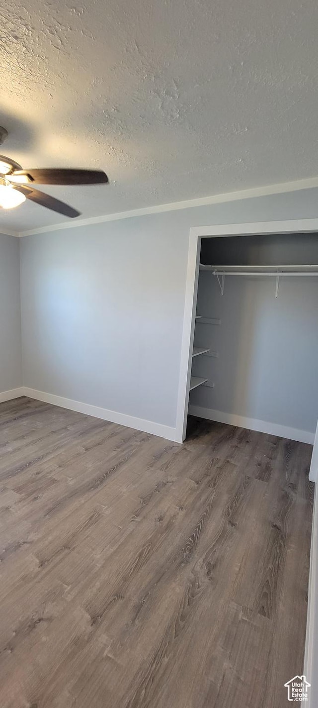325 W Apple St, Grantsville, UT 84029 - unfurnished bedroom with a textured ceiling, wood finished floors, a closet, baseboards, and ceiling fan