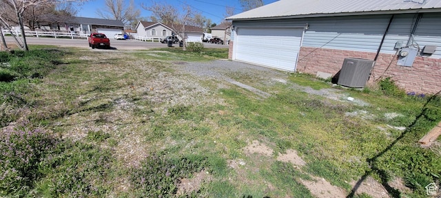 325 W Apple St, Grantsville, UT 84029 - view of yard featuring central AC unit and a garage