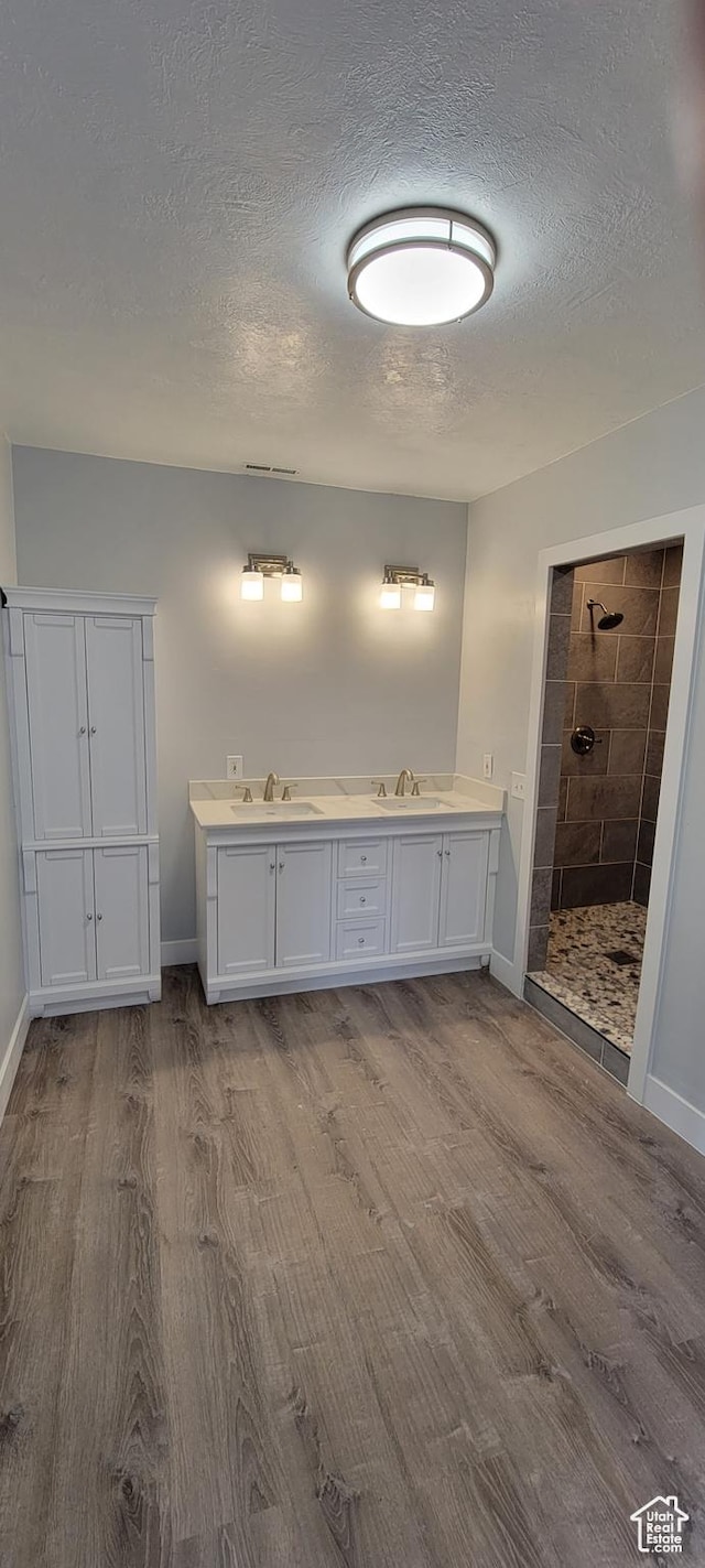 325 W Apple St, Grantsville, UT 84029 - full bathroom featuring wood finished floors, a walk in shower, a textured ceiling, baseboards, and double vanity