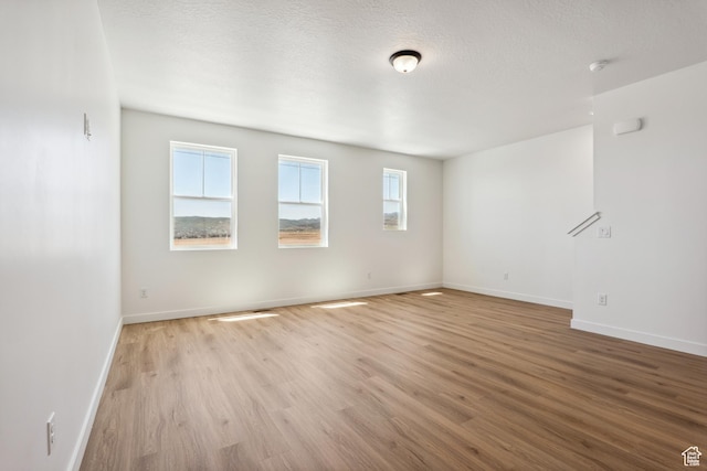 6656 W 11800 S Unit 619, South Jordan, UT 84009 - spare room with light wood finished floors, baseboards, a textured ceiling, and a smoke detector