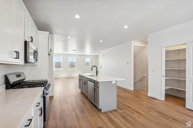 6656 W 11800 S Unit 619, South Jordan, UT 84009 - kitchen featuring stainless steel appliances, light wood-type flooring, recessed lighting, a sink, and white cabinets