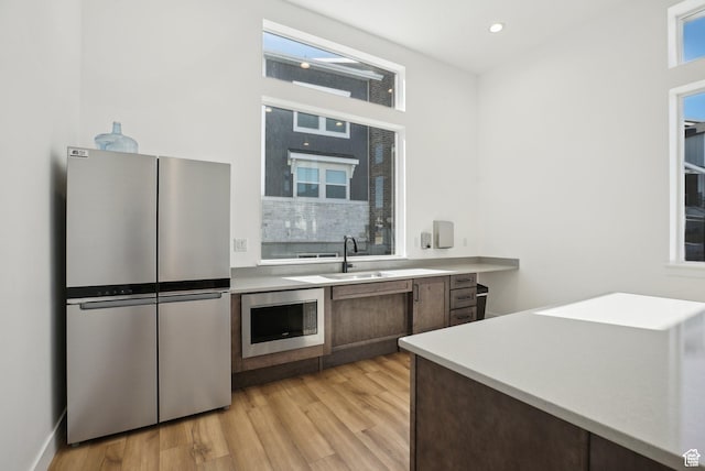 3722 W 1440 N Unit F301, Lehi, UT 84043 - kitchen featuring appliances with stainless steel finishes, a sink, light wood-type flooring, light countertops, and recessed lighting