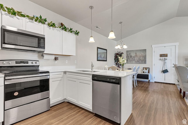 3722 W 1440 N Unit F301, Lehi, UT 84043 - kitchen with appliances with stainless steel finishes, a sink, light wood finished floors, lofted ceiling, and a chandelier