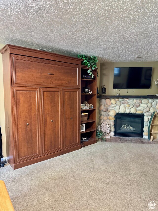815 N Harbor Dr Unit 201, Garden City, UT 84028 - unfurnished living room featuring carpet flooring, a textured ceiling, and a stone fireplace