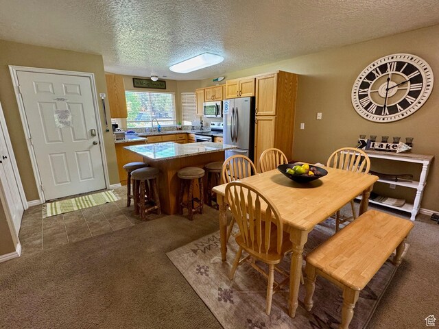 815 N Harbor Dr Unit 201, Garden City, UT 84028 - dining space featuring dark carpet, a textured ceiling, and dark tile patterned flooring