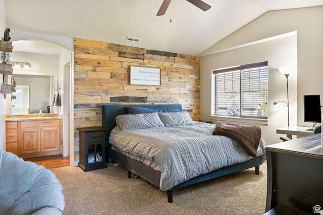 4114 E Cherokee St, Eagle Mountain, UT 84005 - bedroom with wood walls, vaulted ceiling, light carpet, ensuite bathroom, and arched walkways