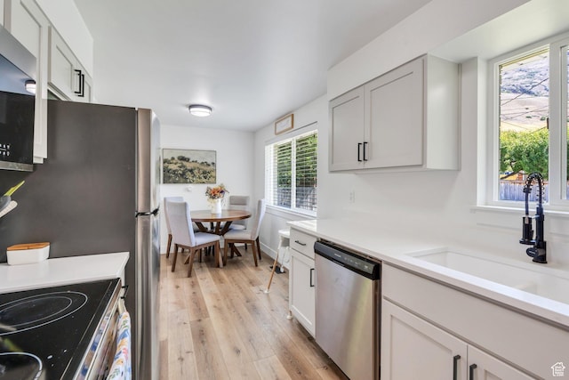 256 N 1040 E, Springville, UT 84663 - kitchen with appliances with stainless steel finishes, a sink, light wood finished floors, and light countertops