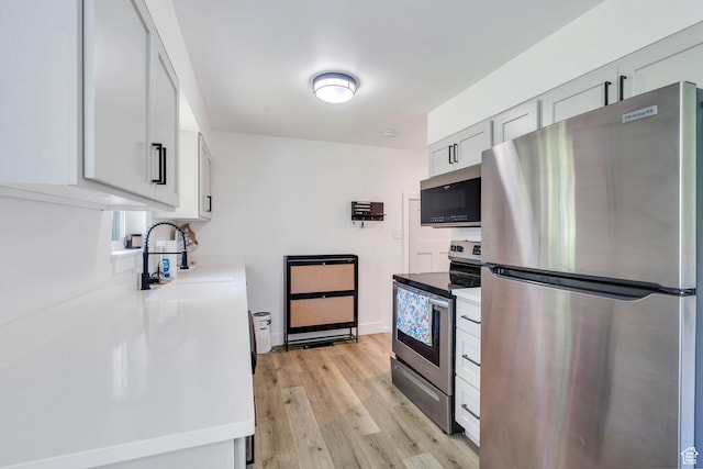 256 N 1040 E, Springville, UT 84663 - kitchen featuring appliances with stainless steel finishes, a sink, light wood-type flooring, and light countertops