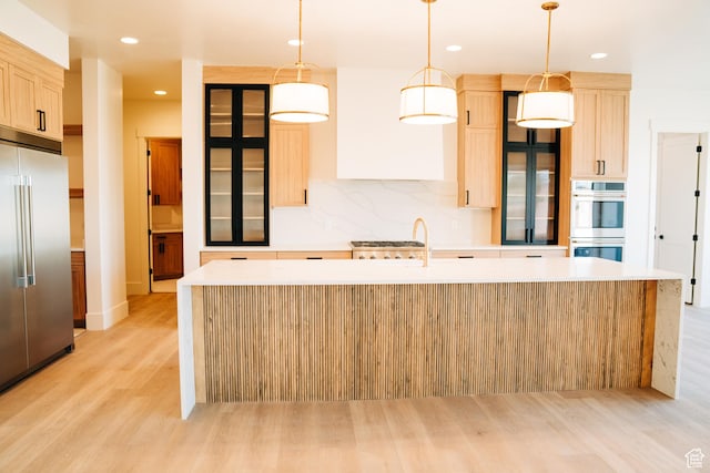 2775 S Rowan Ln, St George, UT 84790 - kitchen featuring stainless steel appliances, light wood-style flooring, an island with sink, light brown cabinets, and light countertops
