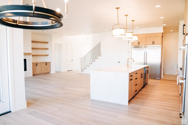 2775 S Rowan Ln, St George, UT 84790 - kitchen with light brown cabinetry, built in fridge, light wood finished floors, a fireplace, and recessed lighting