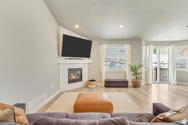 3041 S Hollow Way, Saratoga Springs, UT 84045 - living room with wood finished floors, healthy amount of natural light, a glass covered fireplace, baseboards, and recessed lighting