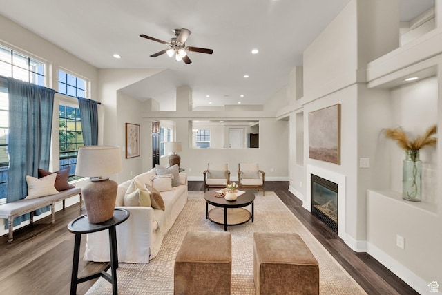 10756 S Navarro Way W, South Jordan, UT 84009 - living room featuring dark wood-type flooring, a glass covered fireplace, a ceiling fan, baseboards, and recessed lighting