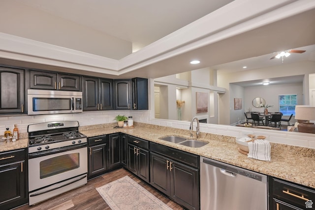 10756 S Navarro Way W, South Jordan, UT 84009 - kitchen with appliances with stainless steel finishes, a sink, wood finished floors, light stone counters, and tasteful backsplash