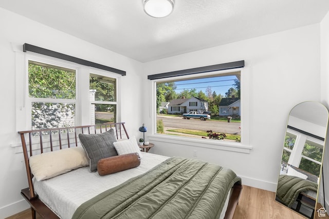 1022 27th St S, Ogden, UT 84403 - bedroom with baseboards, multiple windows, and wood finished floors
