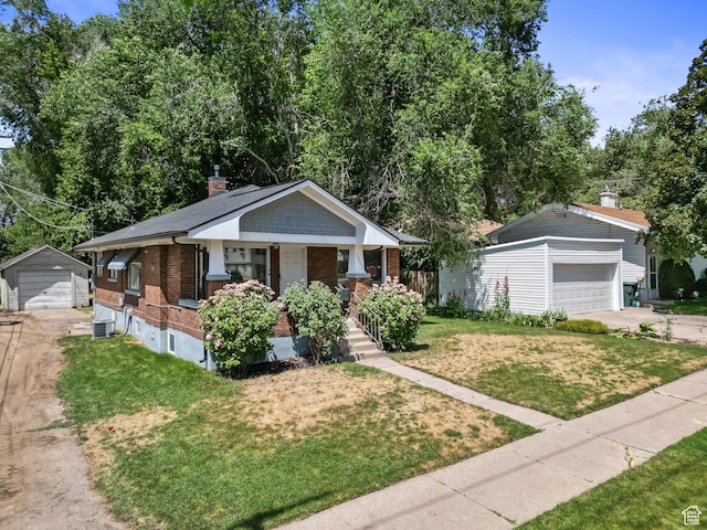 1022 27th St S, Ogden, UT 84403 - view of front of property featuring a detached garage, brick siding, an outbuilding, a front yard, and covered porch