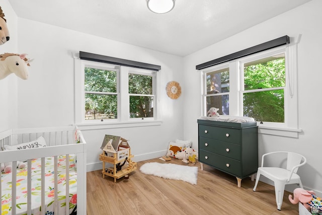1022 27th St S, Ogden, UT 84403 - bedroom featuring multiple windows, wood finished floors, a nursery area, and baseboards