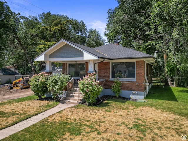 1022 27th St S, Ogden, UT 84403 - bungalow-style home with covered porch, brick siding, a front lawn, and a shingled roof