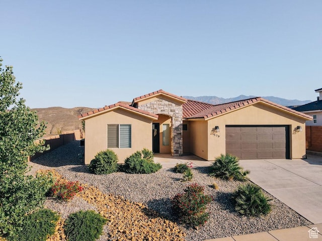 579 N Staci Dr, Hurricane, UT 84737 - mediterranean / spanish-style house featuring a tile roof, a garage, stucco siding, a mountain view, and driveway