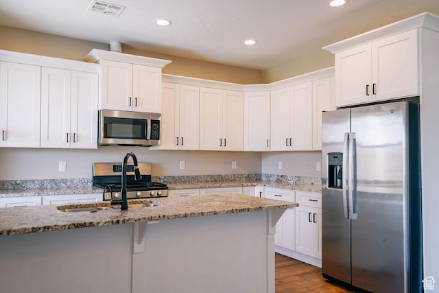 579 N Staci Dr, Hurricane, UT 84737 - kitchen featuring appliances with stainless steel finishes, recessed lighting, white cabinetry, wood finished floors, and light stone countertops