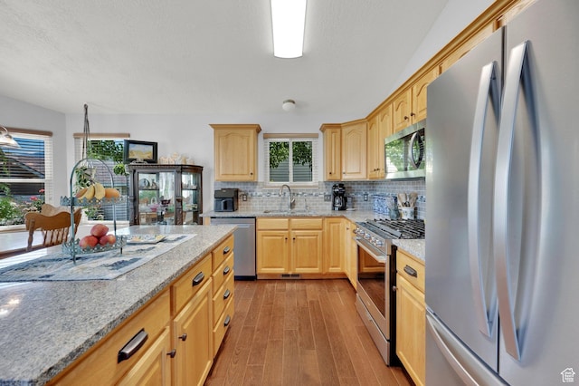 7443 W Perennial Dr, Magna, UT 84044 - kitchen featuring appliances with stainless steel finishes, light brown cabinetry, light wood-style floors, and tasteful backsplash