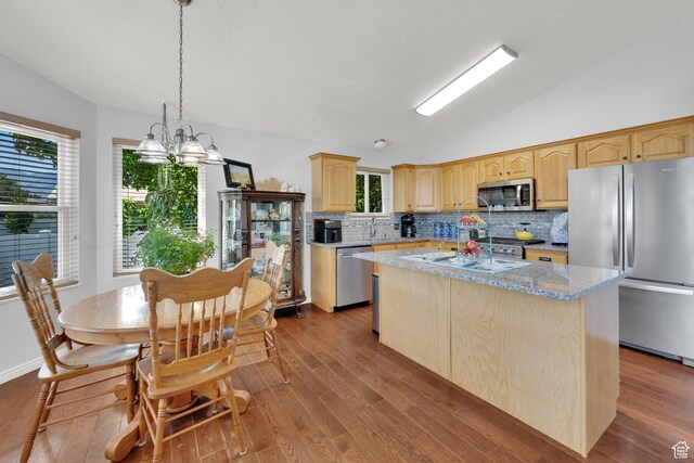 7443 W Perennial Dr, Magna, UT 84044 - kitchen featuring appliances with stainless steel finishes, lofted ceiling, light brown cabinets, tasteful backsplash, and wood finished floors