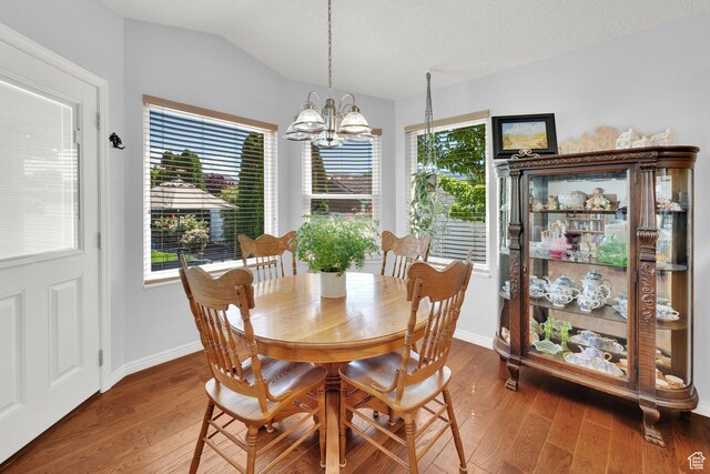 7443 W Perennial Dr, Magna, UT 84044 - dining space with a chandelier, wood finished floors, lofted ceiling, and healthy amount of natural light