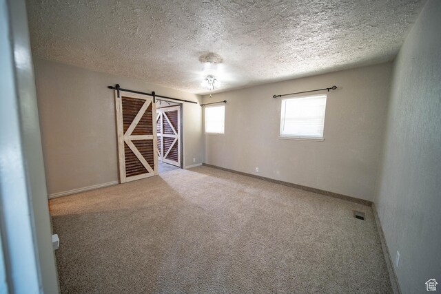617 Aspen Cir, Price, UT 84501 - carpeted spare room featuring a barn door and a textured ceiling