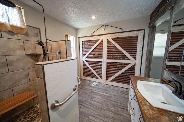 617 Aspen Cir, Price, UT 84501 - bathroom with a textured ceiling, walk in shower, and vanity