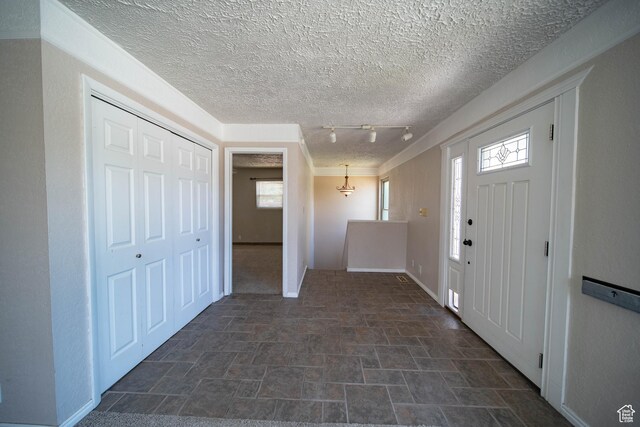 617 Aspen Cir, Price, UT 84501 - entryway featuring stone finish floors, rail lighting, and a textured ceiling