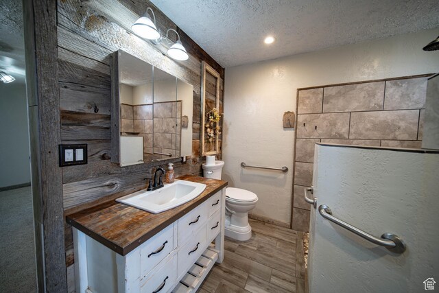 617 Aspen Cir, Price, UT 84501 - bathroom featuring a textured ceiling, vanity, wood finished floors, and decorative backsplash