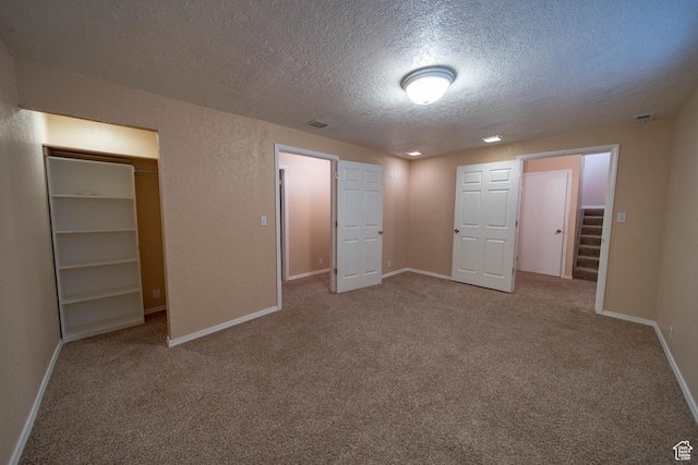 617 Aspen Cir, Price, UT 84501 - unfurnished bedroom with a textured ceiling, carpet floors, a closet, and a walk in closet