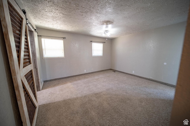 617 Aspen Cir, Price, UT 84501 - carpeted empty room with a barn door and a textured ceiling