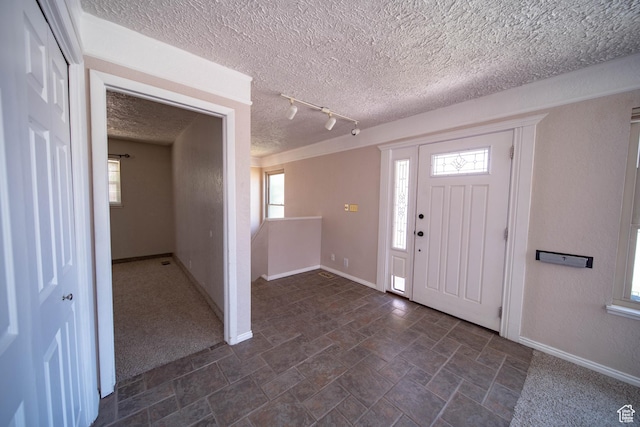 617 Aspen Cir, Price, UT 84501 - foyer entrance with a textured ceiling, healthy amount of natural light, dark stone finish flooring, and rail lighting