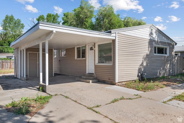 1866 E Village Rd S, Salt Lake City, UT 84121 - view of front of home with driveway, an attached carport, and entry steps