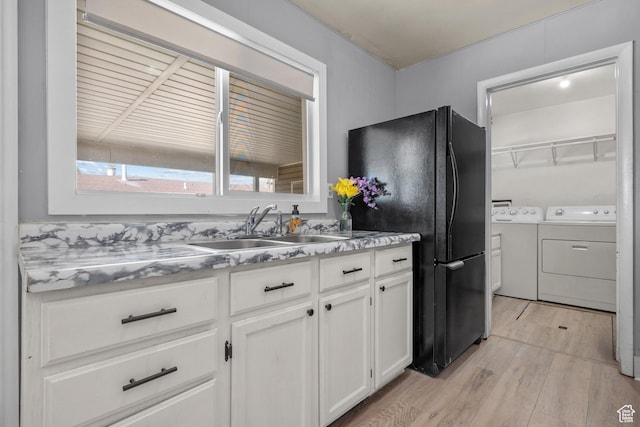1866 E Village Rd S, Salt Lake City, UT 84121 - kitchen with washing machine and dryer, light wood finished floors, freestanding refrigerator, white cabinets, and light countertops