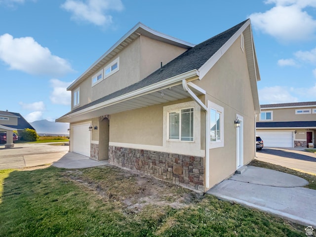 2238 N Harvest Moon Dr, Saratoga Springs, UT 84045 - view of home's exterior featuring stone siding, stucco siding, an attached garage, and concrete driveway