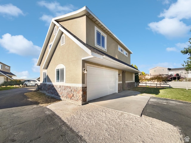 2238 N Harvest Moon Dr, Saratoga Springs, UT 84045 - view of side of property featuring stone siding, stucco siding, driveway, and a garage