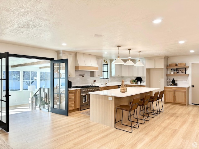 5862 S Ayrshire Dr, Murray, UT 84107 - kitchen with double oven range, custom range hood, light wood-style flooring, light countertops, and recessed lighting