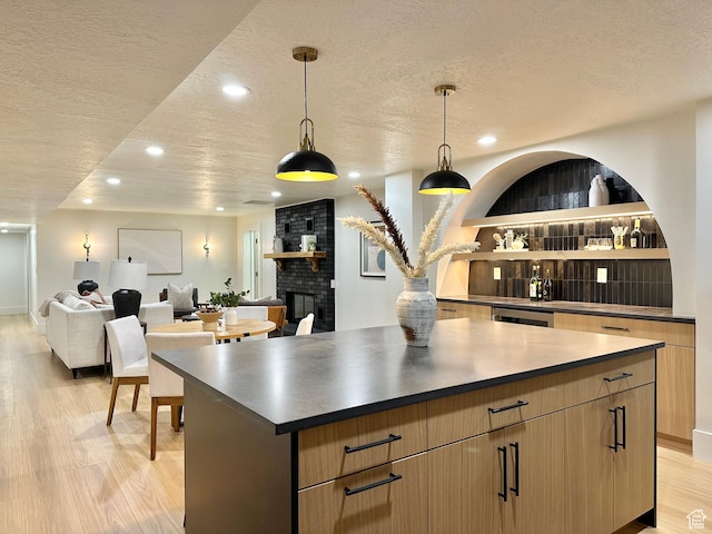 5862 S Ayrshire Dr, Murray, UT 84107 - kitchen featuring a textured ceiling, a center island, light wood-style floors, recessed lighting, and a fireplace