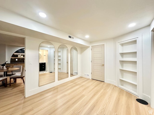 5862 S Ayrshire Dr, Murray, UT 84107 - basement with built in shelves, light wood-style floors, recessed lighting, and arched walkways