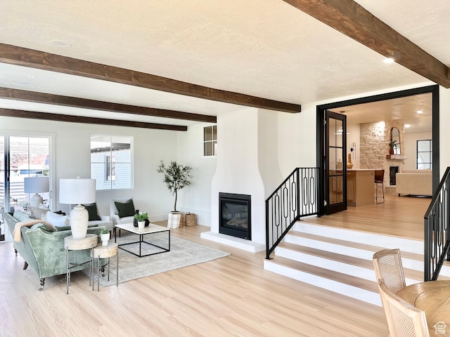 5862 S Ayrshire Dr, Murray, UT 84107 - living area with a large fireplace, light wood finished floors, beam ceiling, and stairway