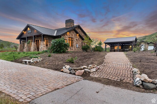 370 S Got Teeth Ln E, Emigration Canyon, UT 84108 - view of front of property featuring stone siding, a standing seam roof, a chimney, and a metal roof