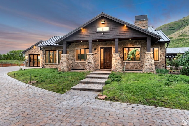 370 S Got Teeth Ln E, Emigration Canyon, UT 84108 - craftsman house with stone siding, a chimney, decorative driveway, a standing seam roof, and an attached garage